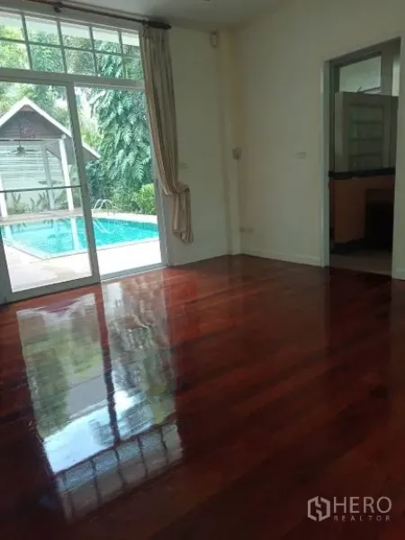 Detached House for rent in Bang Rak, Bangkok - Ground-floor room with glossy hardwood floors and sliding doors opening to the pool terrace.