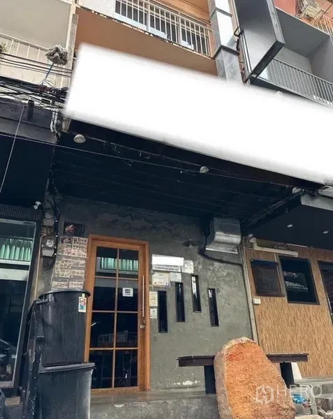 店屋 出租或出售在Watthana, Bangkok - 店屋临街外立面，玻璃门、狭长窗与混凝土墙面，黑色深檐可装招牌。