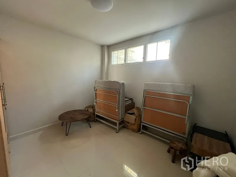 Townhouse for rent in Din Daeng, Bangkok - Multi-purpose room with small high windows and stored folding beds.