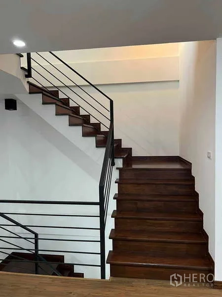 带办公室的家 出租在Bueng Kum, Bangkok - 深色木楼梯配黑色金属扶手，连接多层空间。