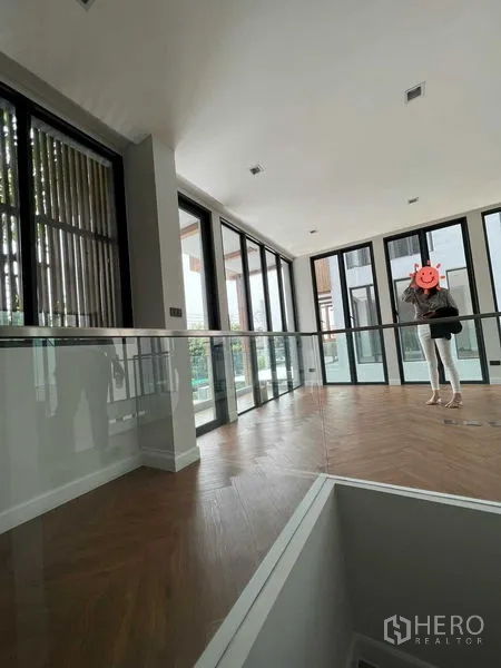 带办公室的家 出售在Wang Thonglang, Bangkok - 开放办公/活动区，落地推拉门、玻璃护栏与木地板。
