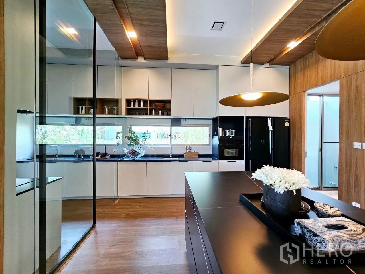 Detached House for rent in Saphan Sung, Bangkok - Glass-partitioned kitchen with black appliances and island tray.