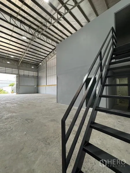 Warehouse for rent in Mueang Pathum Thani, Pathum Thani - Staircase beside the internal office leading to the upper level beneath the tall roof.