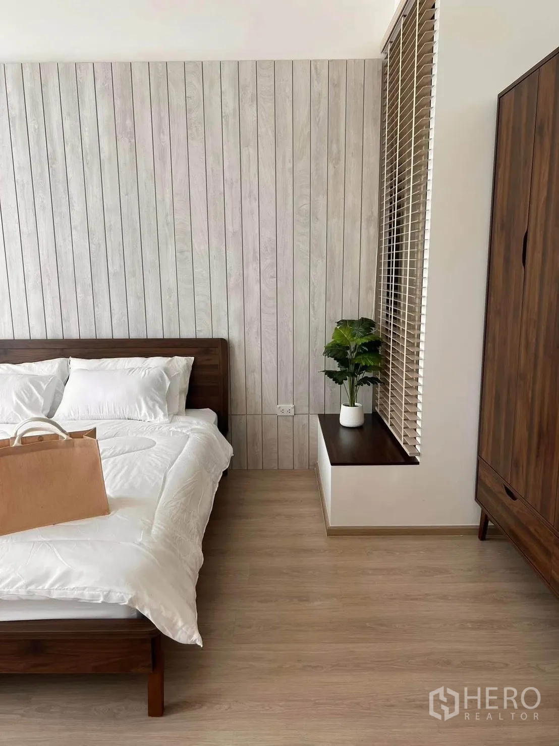 Townhouse for rent in Bang Phli, Samut Prakan - Cozy bedroom featuring a wood panel accent wall, bedside ledge, and wardrobe.
