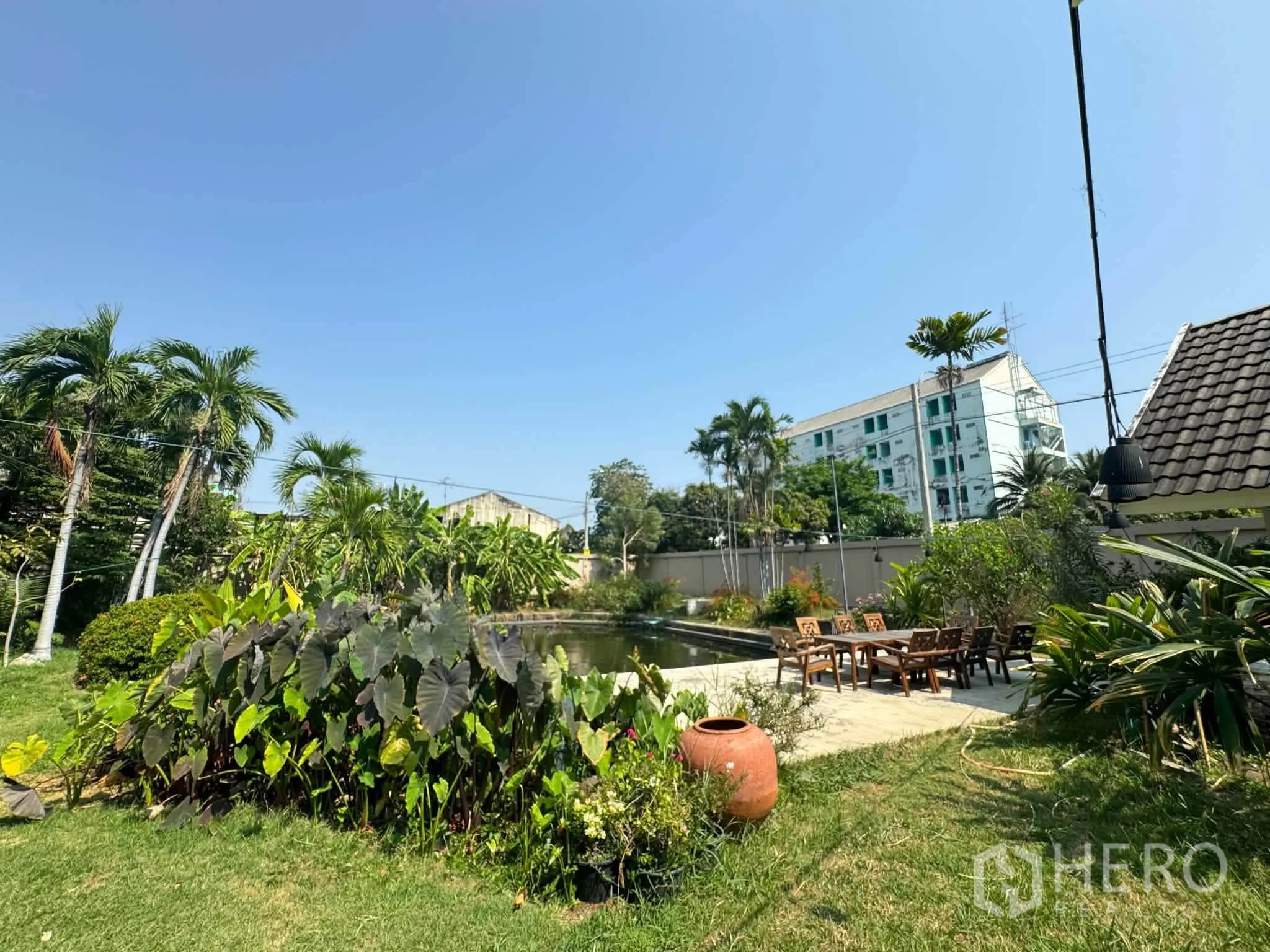บ้านเดี่ยว for rent or sale in Mueang Samut Prakan, Samut Prakan - สวนร่มรื่นด้วยปาล์มและที่นั่งพักผ่อนข้างสายน้ำ