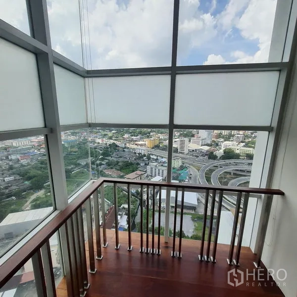 公寓 出租在Bang Kapi, Bangkok - 玻璃观景角，俯瞰城市与高架道路。