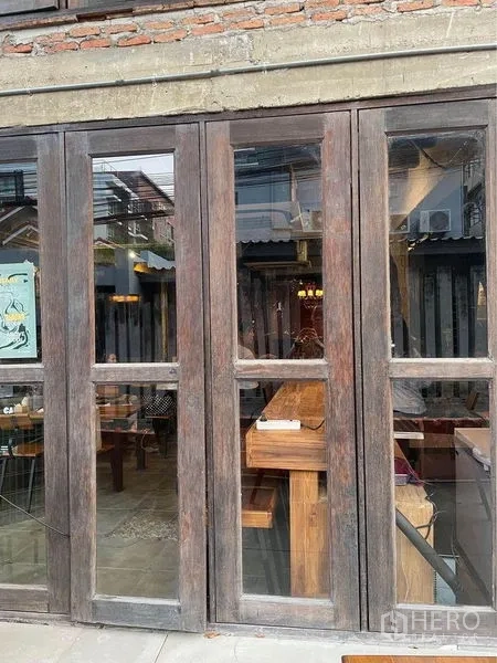 Retail Space for rent in Phaya Thai, Bangkok - Street-facing shopfront with tall wooden-framed glass doors showcasing a warm interior and bar counter.