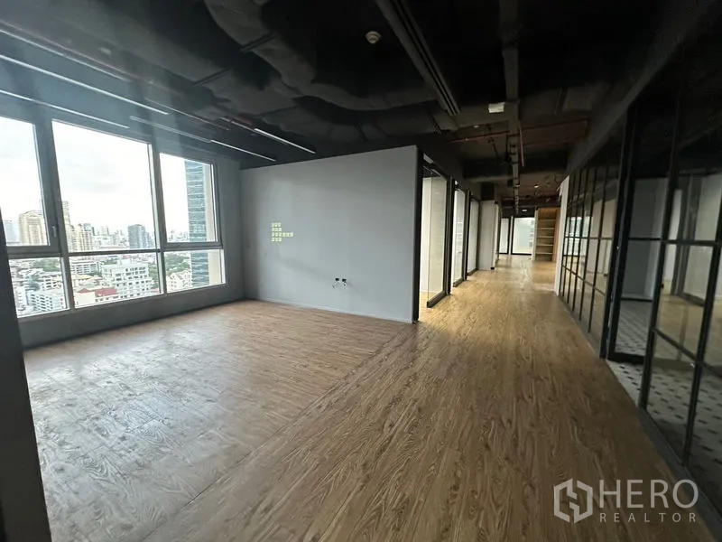 办公空间 出租在Bang Rak, Bangkok - 靠大窗的角落工作区，旁连玻璃走廊