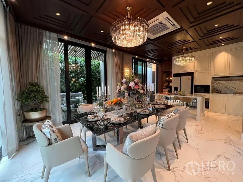 Detached House for sale in Yan Nawa, Bangkok - Elegant dining room with crystal chandeliers, marble floor and sliding doors to a garden patio.
