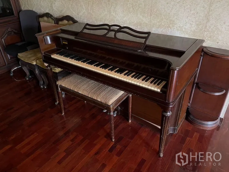 Home Office for rent in Watthana, Bangkok - Close-up of classic upright piano with bench on polished wood flooring.