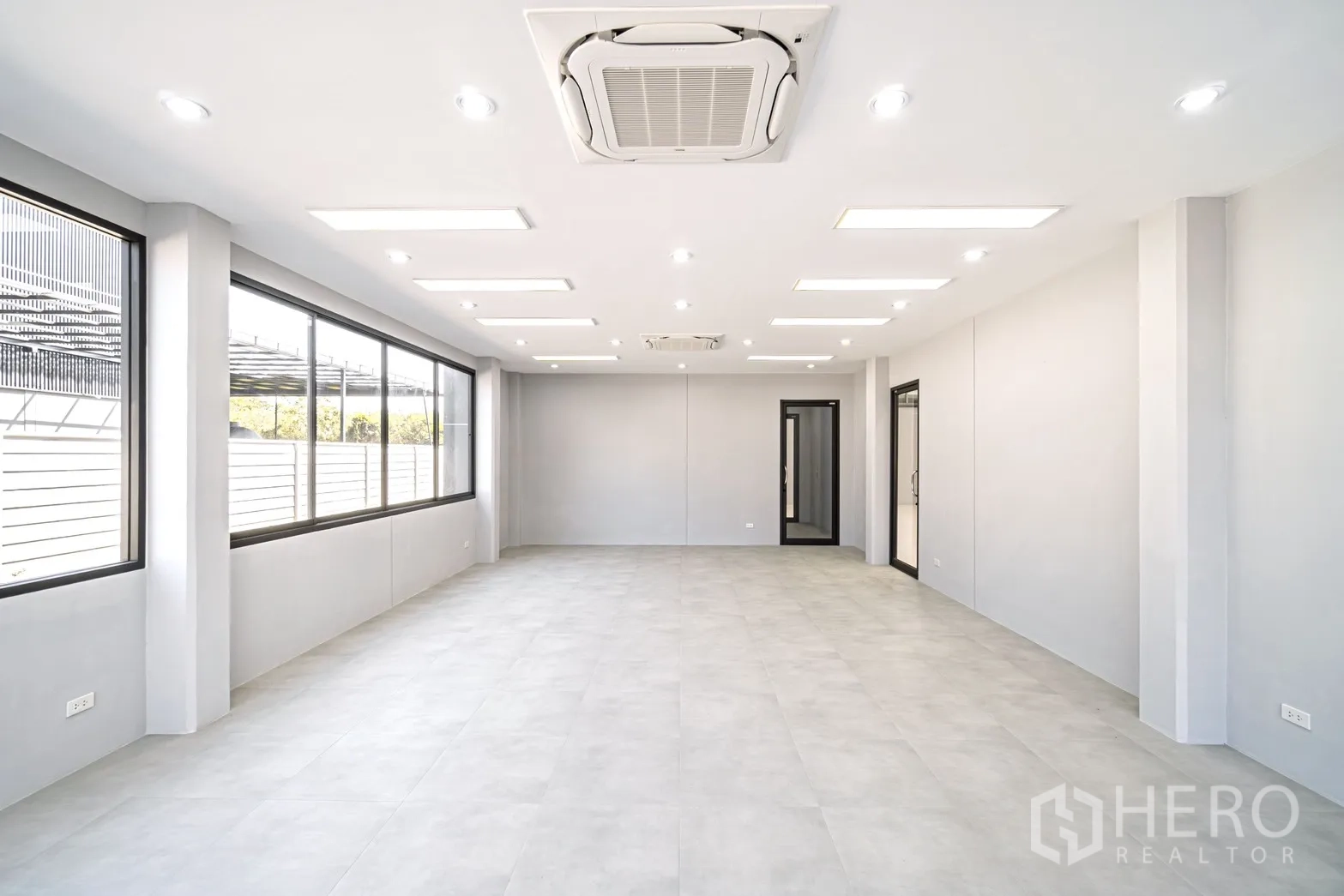 工厂 for rent or sale in Lam Luk Ka, Pathum Thani - 大型办公区域，落地窗、筒灯照明与简洁装饰。