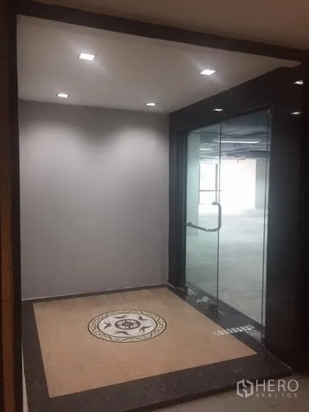 办公空间 出租在Watthana, Bangkok - 玻璃门入口大堂，嵌入式筒灯与地面拼花装饰