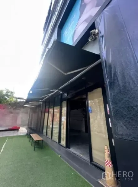 Retail Space for rent - Angled view of the shopfront showing the extended awning, glass entrance and outdoor bench.