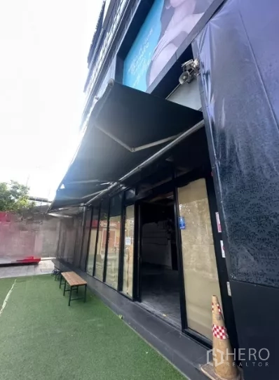 Retail Space for rent - Angled view of the shopfront showing the extended awning, glass entrance and outdoor bench.