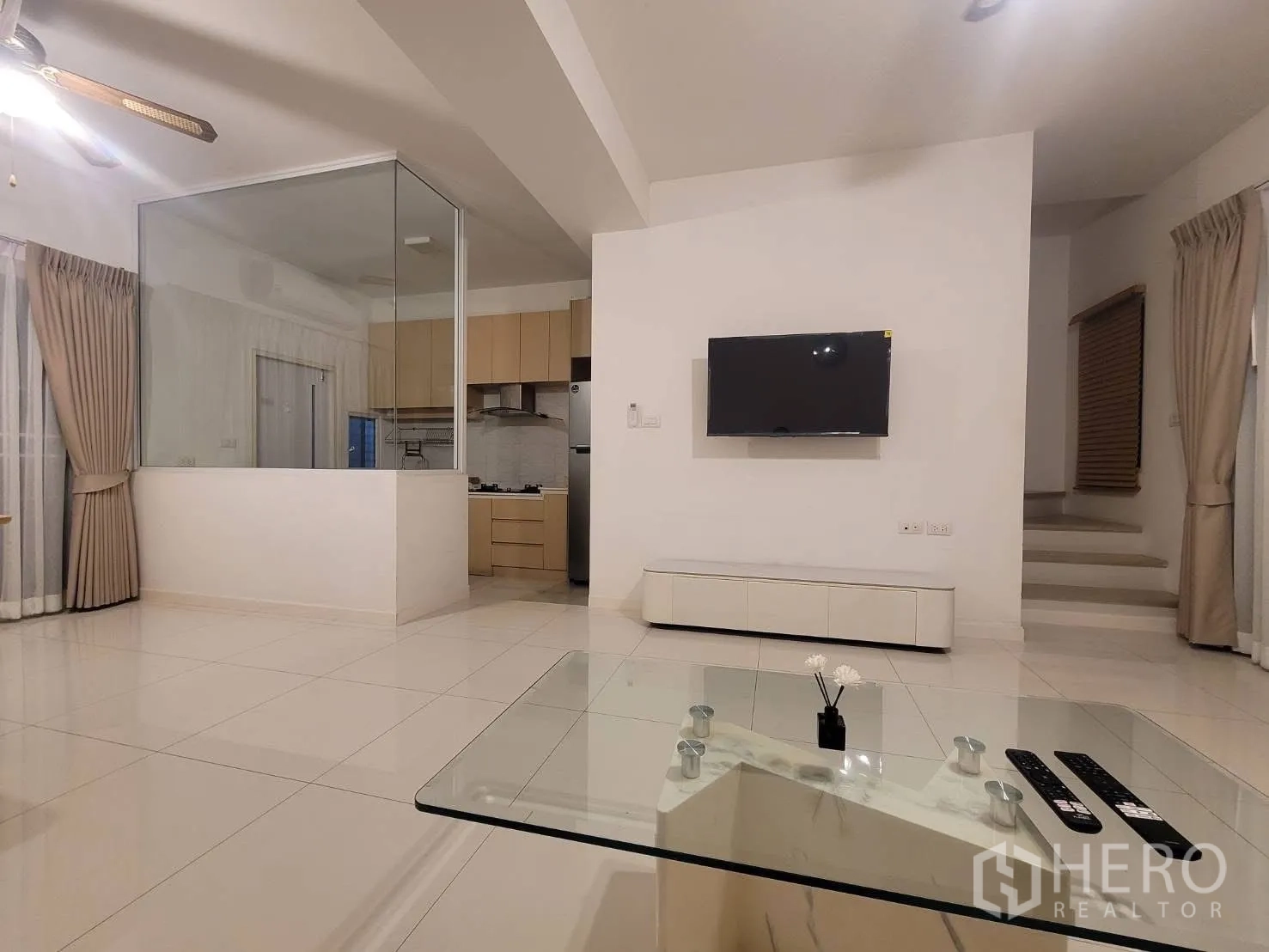 联排别墅 出租在Prawet, Bangkok - 从客厅望向玻璃隔断厨房与电视墙的景观。