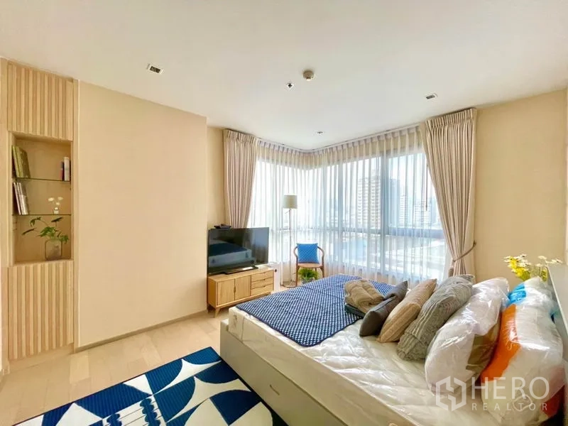 Condominium for rent or sale in Watthana, Bangkok - Master bedroom with corner floor‑to‑ceiling windows, city view and TV console.