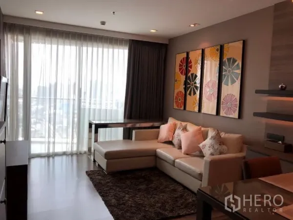 คอนโด ให้เช่าหรือขายในWatthana, Bangkok - ห้องนั่งเล่นพร้อมโซฟา L เปิดสู่ระเบียงผ่านผ้าม่านโปร่ง มองเห็นวิวเมือง
