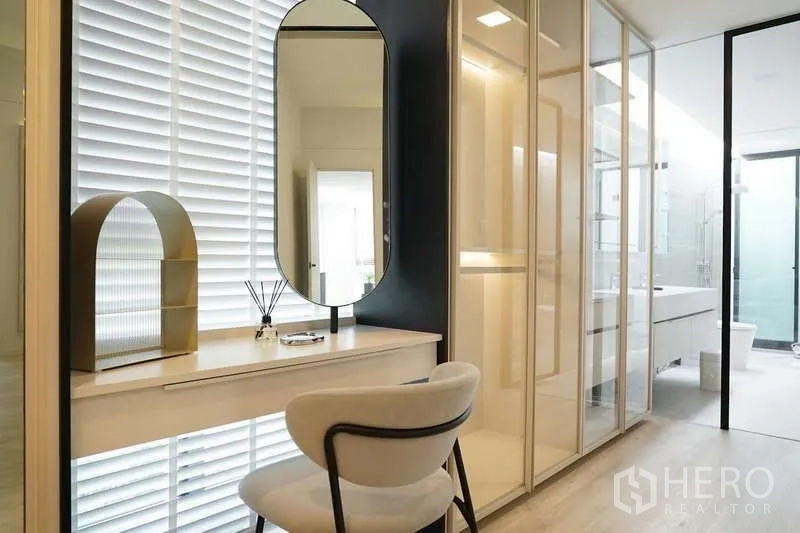 Detached House for rent in Saphan Sung, Bangkok - Dressing area with illuminated vanity table and glass wardrobes leading to the ensuite bathroom.