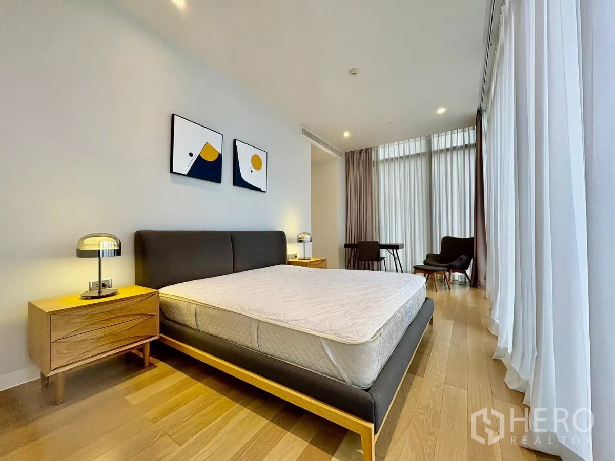 公寓 出租在Watthana, Bangkok - 宽敞卧室，双人床、休闲角与薄纱窗帘。