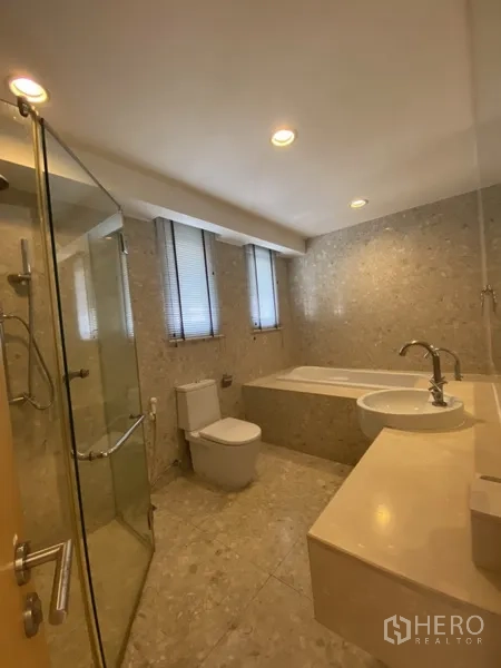 房间 出租在Watthana, Bangkok - 浴室设浴缸、玻璃淋浴间、台盆与马桶，石材饰面。