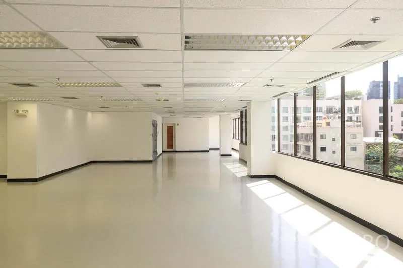 Office Space for rent in Bang Rak, Bangkok - Corner office area with long rows of windows bringing in natural light over an open workspace.