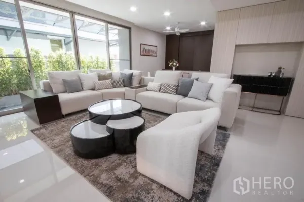 บ้าน ขายในSaphan Sung, Bangkok - ห้องนั่งเล่นกว้าง โซฟาตัวใหญ่ โต๊ะกลางดีไซน์ และหน้าต่างกระจกบานเลื่อน