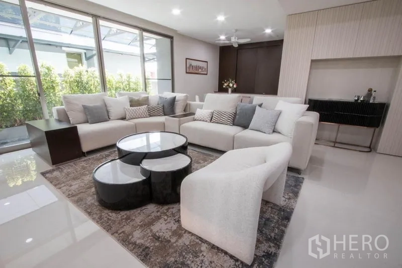 บ้าน ขายในSaphan Sung, Bangkok - ห้องนั่งเล่นกว้าง โซฟาตัวใหญ่ โต๊ะกลางดีไซน์ และหน้าต่างกระจกบานเลื่อน