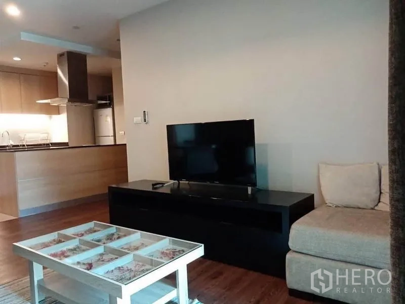Condominium for rent in Sathon, Bangkok - Media corner with flat-screen TV on a low cabinet, chaise lounge and glass-top coffee table.