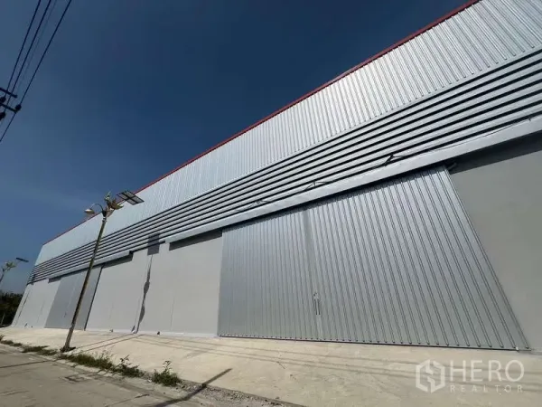 货栈 出租在Prawet, Bangkok - 仓库长立面，特大推拉门与上部通风板。