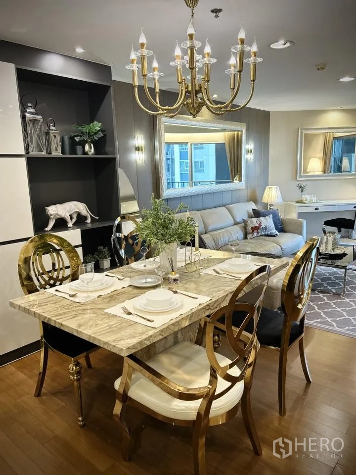Condominium for rent in Huai Khwang, Bangkok - Dining area opening to living room with chandelier.