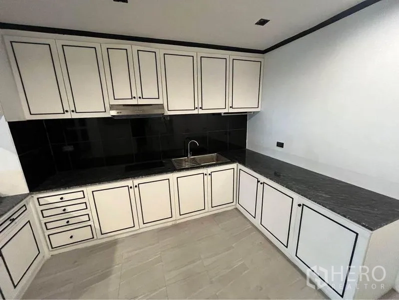 Condominium for rent or sale in Watthana, Bangkok - Modern kitchen corner with abundant cabinetry and stainless sink.