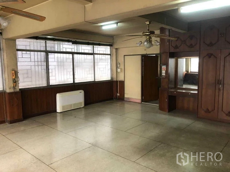 Shophouse for rent in Khlong Toei, Bangkok - Open-plan floor with ceiling fan, built-in cabinet and multiple windows.