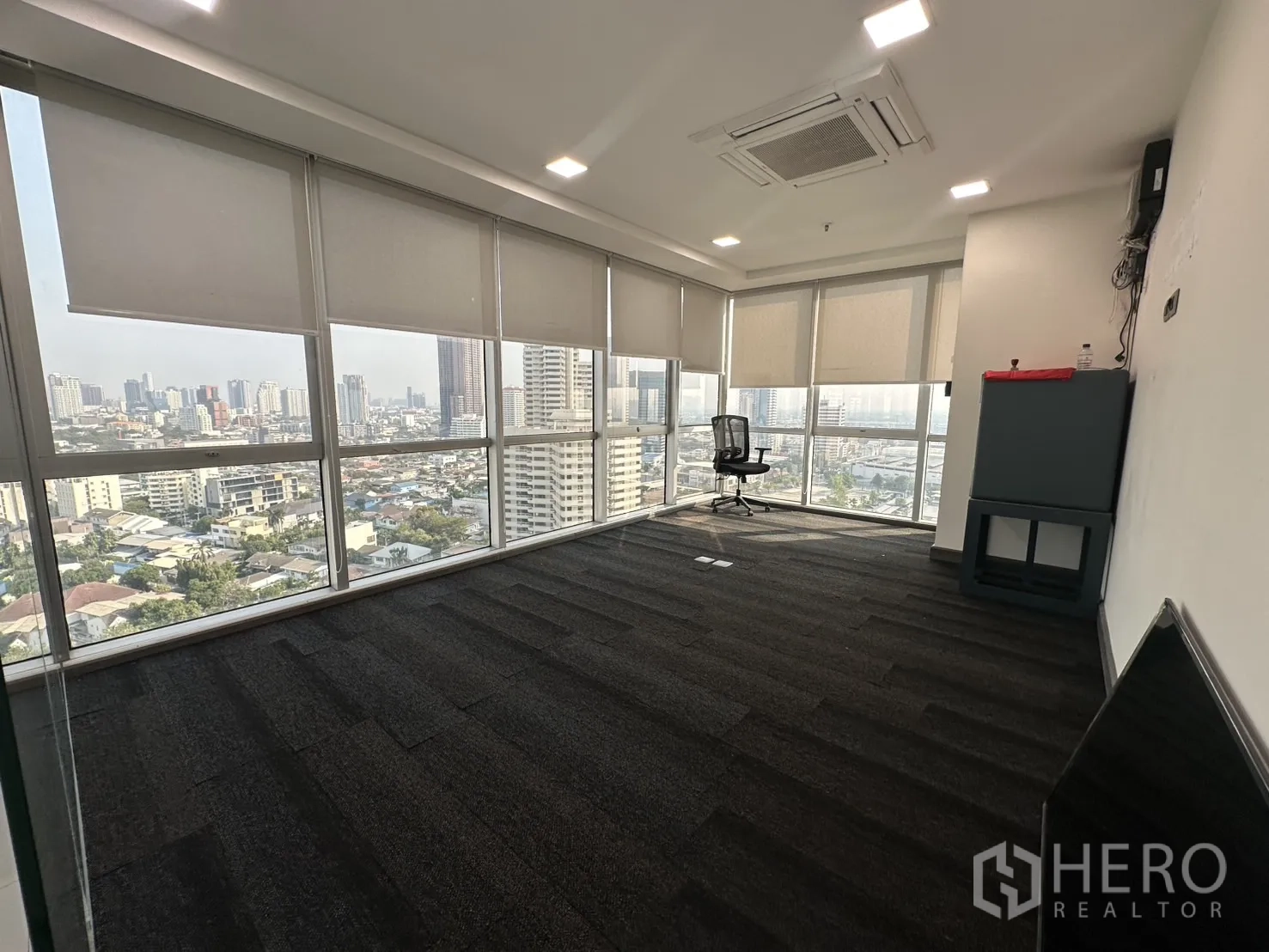 Office Space for rent - Carpeted corner meeting room with wraparound windows and blinds.