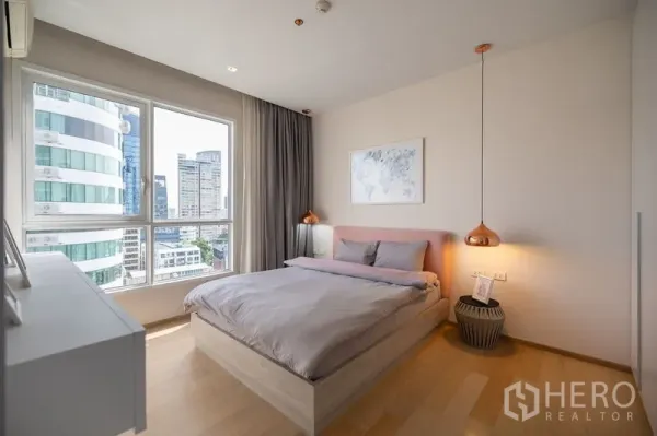 公寓 出租在Watthana, Bangkok - 卧室设大窗户，俯瞰城市高楼景观。