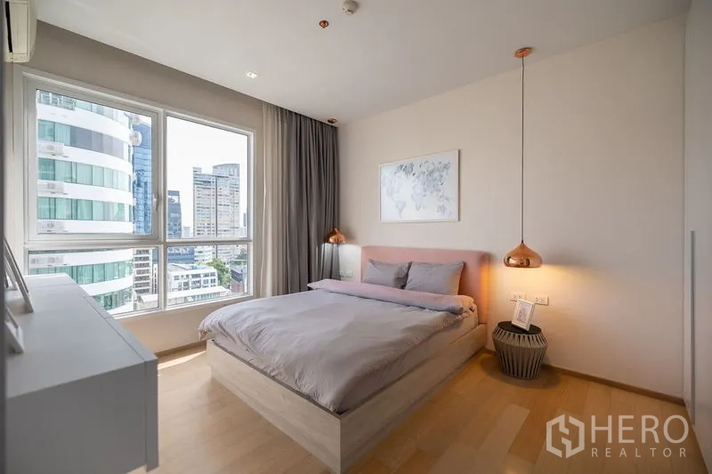 公寓 出租在Watthana, Bangkok - 卧室设大窗户，俯瞰城市高楼景观。