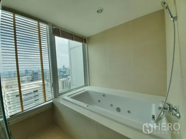 公寓 出租在Ratchathewi, Bangkok - 内置按摩浴缸临窗而设，米色墙砖并欣赏城市景观。