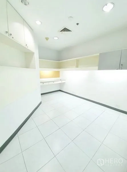 Office Space for rent in Bang Na, Bangkok - Compact workroom with built-in cabinets, white tile floor and recessed lighting.