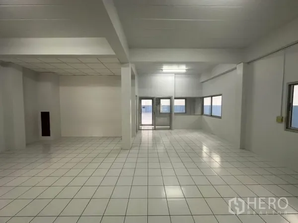 Factory for rent in Pathum Thani - Bright tiled production or office area with windows and double glass doors.