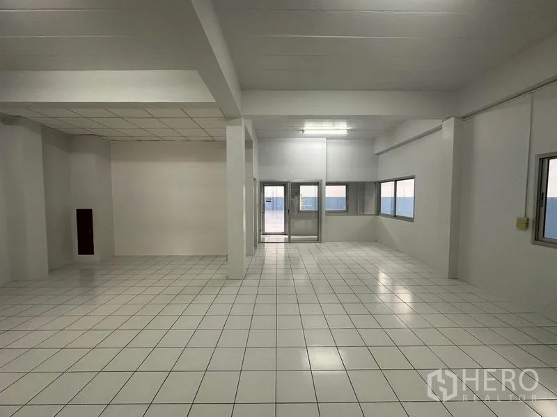 Factory for rent in Pathum Thani - Bright tiled production or office area with windows and double glass doors.