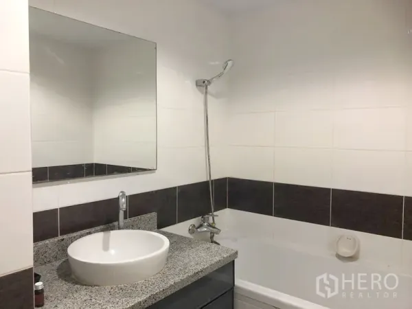 Condominium for rent or sale in Khlong Toei, Bangkok - Bathroom with granite-top vanity and a bathtub with shower.