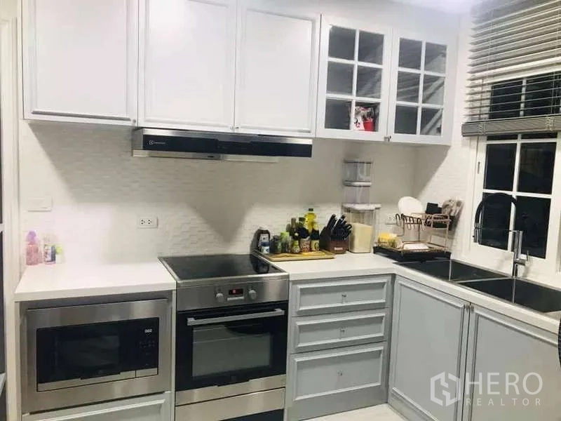 บ้าน ให้เช่าในChom Thong, Bangkok - ครัวรูปตัวแอล พร้อมเตาอบ ไมโครเวฟ เครื่องดูดควัน และอ่างล้างจานคู่ติดหน้าต่าง