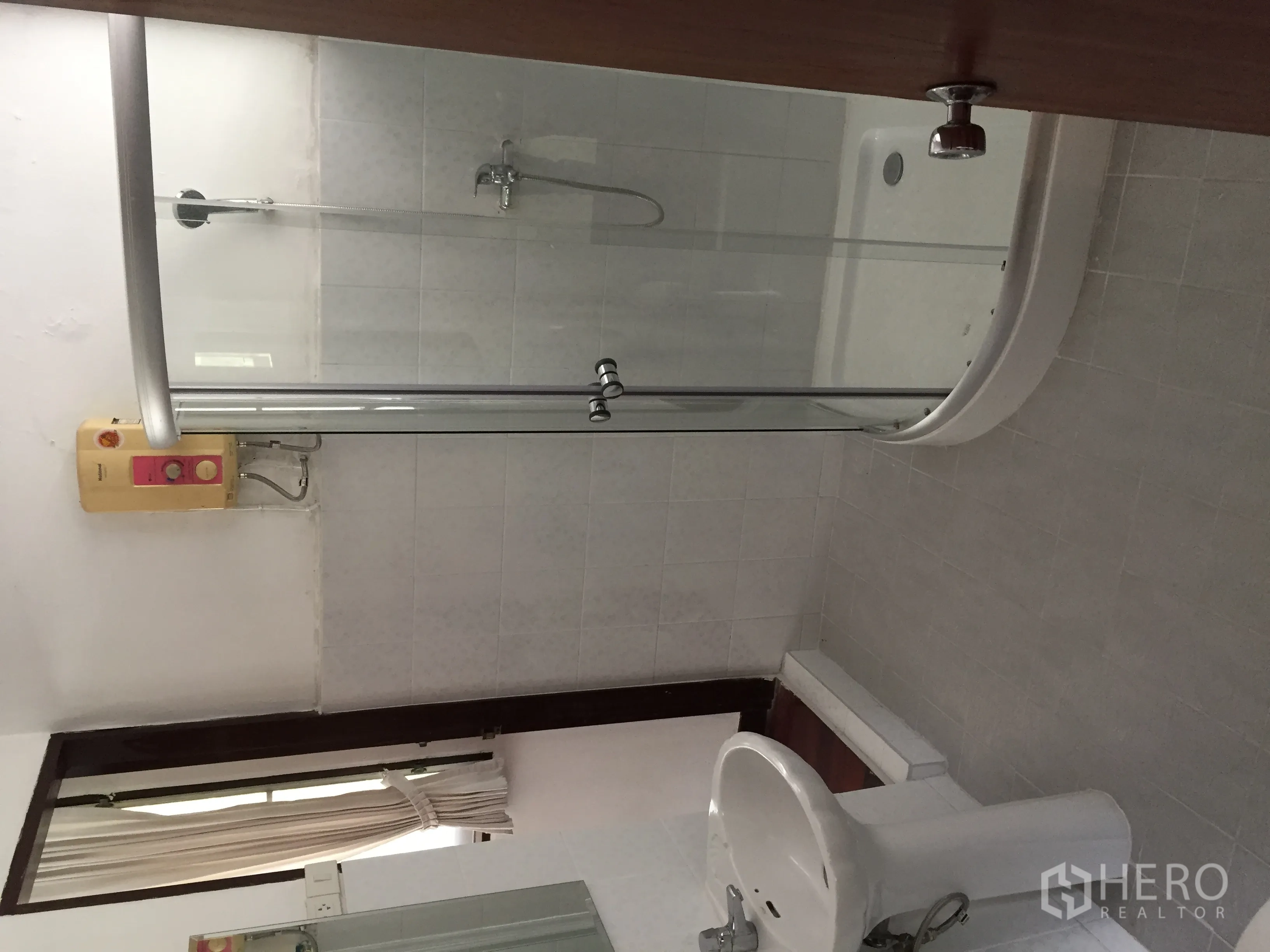 Townhouse for rent in Yan Nawa, Bangkok - Clean bathroom with curved glass shower, pedestal sink and heater.