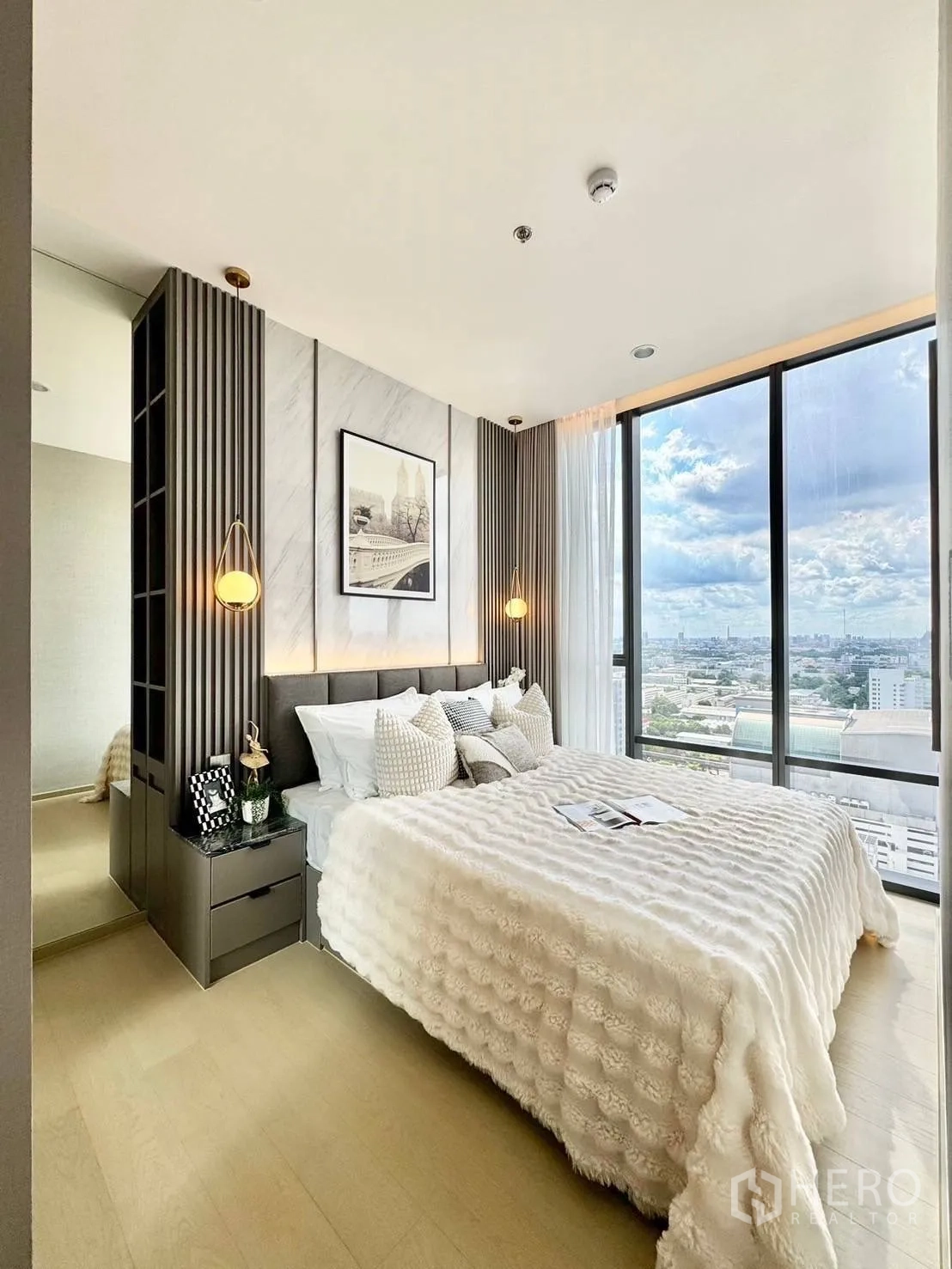 Condominium for rent in Ratchathewi, Bangkok - Bedroom with large window showcasing city view, bedside tables, and soft bedding.