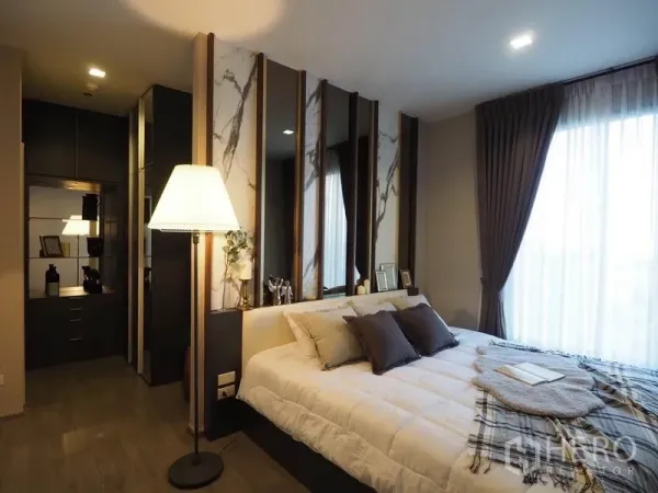 Condominium for rent in Khlong San, Bangkok - Master bedroom with marble-accent headboard, built-in wardrobe, and wide window.