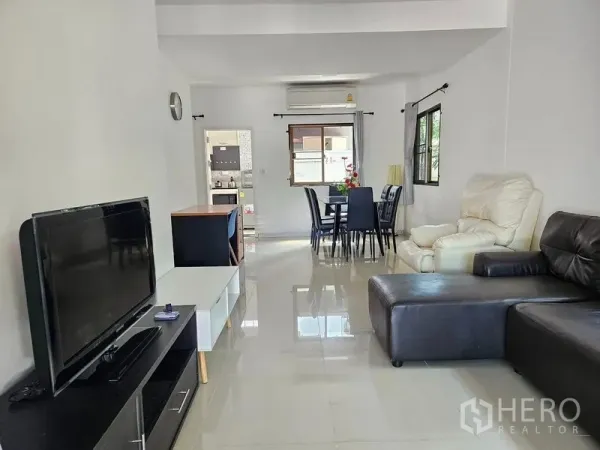 Townhouse for rent - Bright open-plan living and dining area with leather sofas, TV unit and glossy tiled floors.