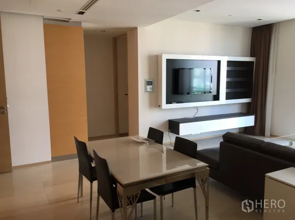Condominium for rent or sale in Bang Rak, Bangkok - TV feature wall with floating cabinet facing the dining area in a modern condo.