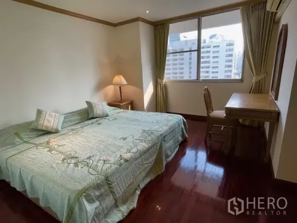 公寓 出租或出售在Watthana, Bangkok - 次卧带大床、书桌与城市景观窗，绿色窗帘点缀。