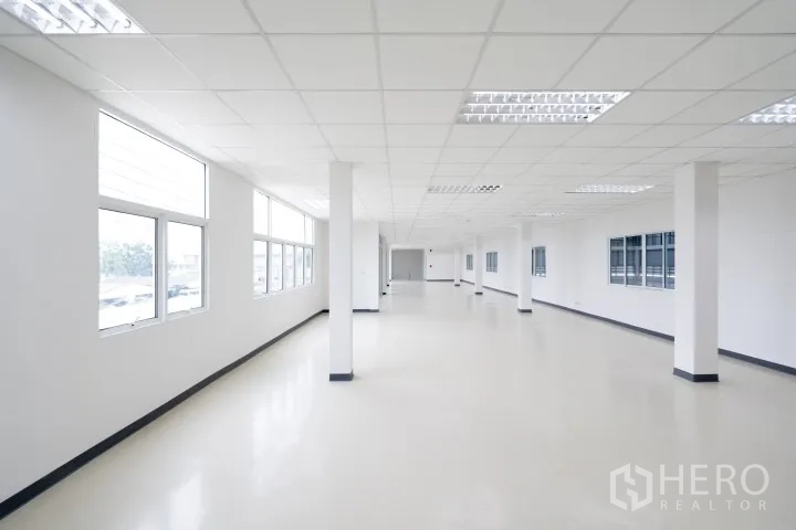 Factory for rent in Khlong Luang, Pathum Thani - Spacious open-plan office with multiple windows and columns.