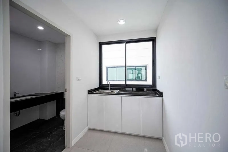 带办公室的家 出租在Suan Luang, Bangkok - 小型茶水间，设窗与黑色操作台，紧邻瓷砖卫浴。