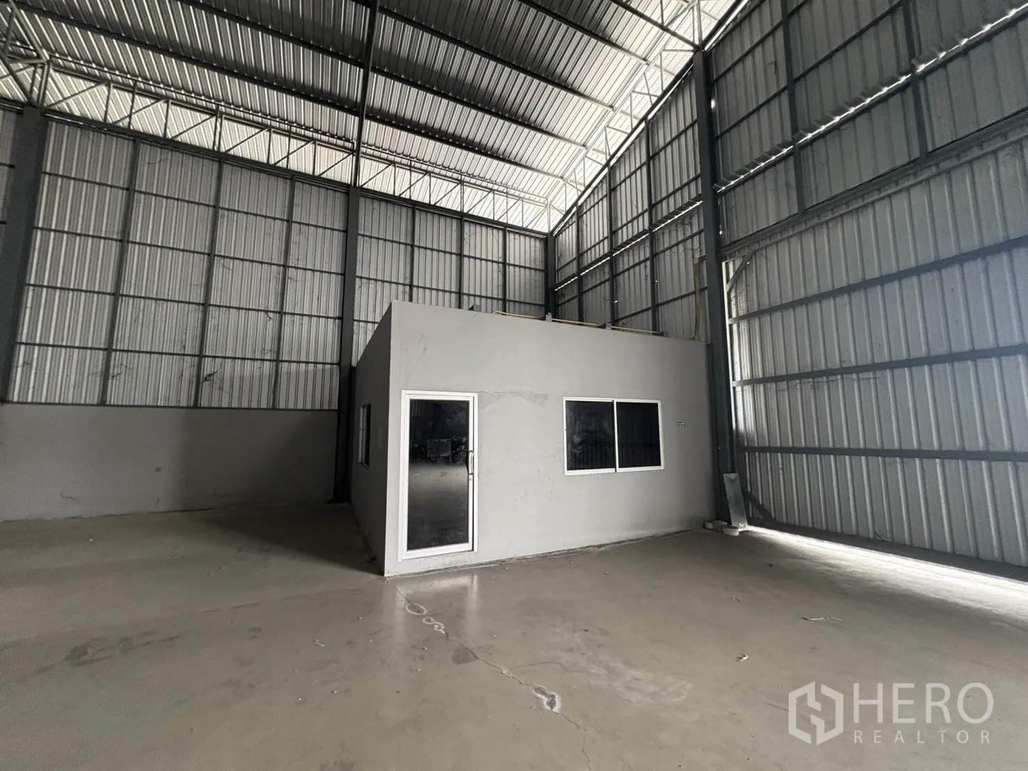 Warehouse for rent in Mueang Samut Prakan, Samut Prakan - Close‑up of the freestanding office room inside the warehouse with door and windows.